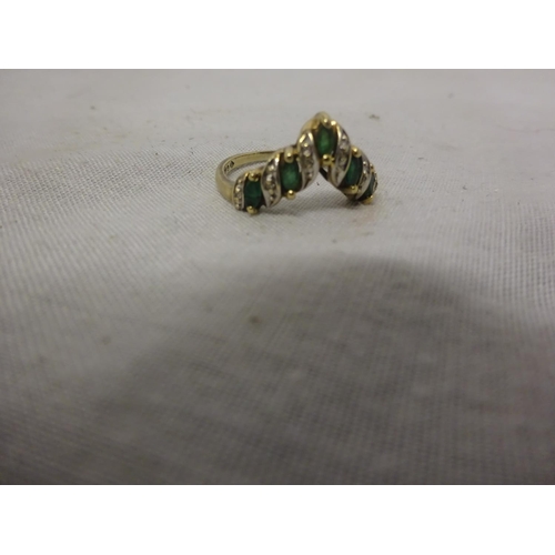 221 - A 10k emerald and diamond ring set with 5 marquise/shaped pale emeralds, edged  by small brilliant c... 