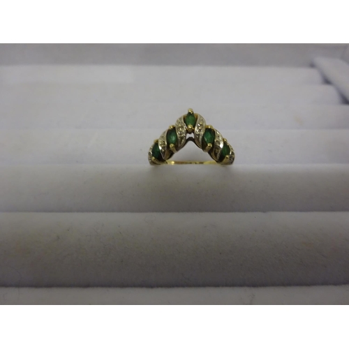 221 - A 10k emerald and diamond ring set with 5 marquise/shaped pale emeralds, edged  by small brilliant c... 