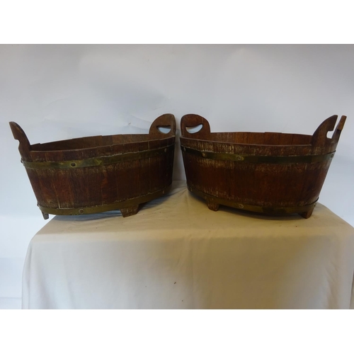 35 - A pair of antique oak and brass bound oval shaped vats. W. 50cm, D. 35cm, H. 20cm.  (one handle miss... 