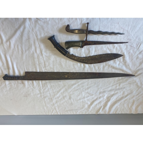 439 - A Gurka knife, two daggers and a long edged weapon in need of restoration.