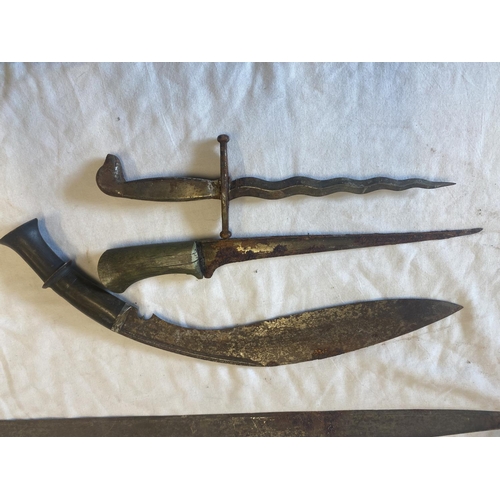 439 - A Gurka knife, two daggers and a long edged weapon in need of restoration.