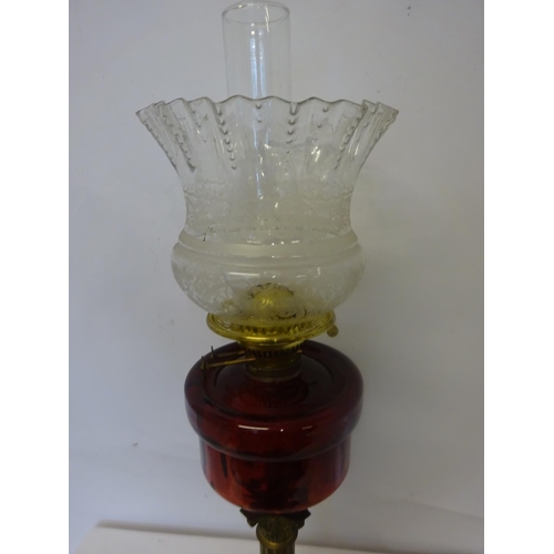 93 - Antique brass oil lamp with red glass bowl and decorative shade.