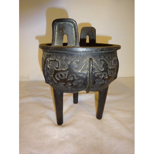 498 - Antique Chinese bronze incense burner of circular form with two handles and raised on three legs.
He... 