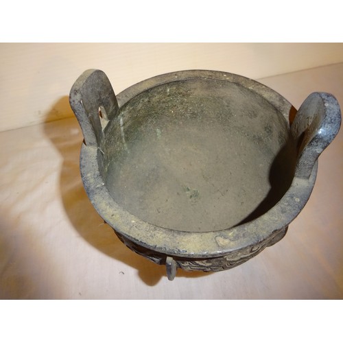 498 - Antique Chinese bronze incense burner of circular form with two handles and raised on three legs.
He... 