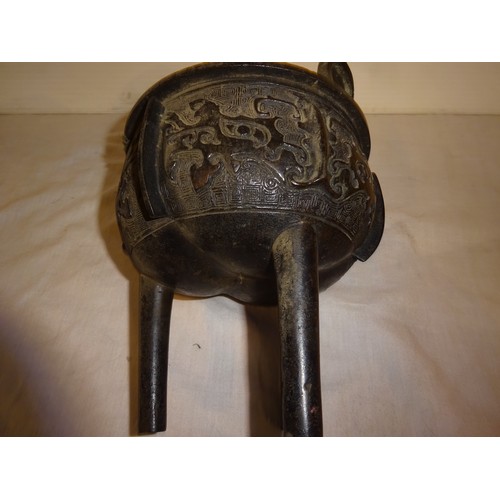 498 - Antique Chinese bronze incense burner of circular form with two handles and raised on three legs.
He... 