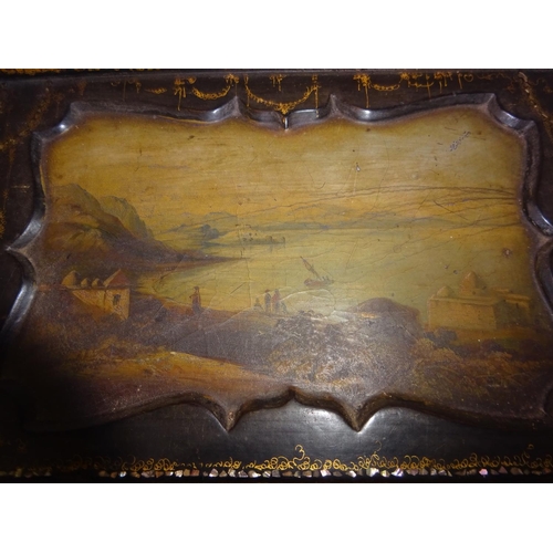 377 - A Victorian paper mache writing slope having landscape scenes and gilt decoration.