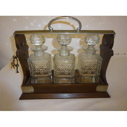 401 - Victorian tantalus having 3 cut glass bottles and key.