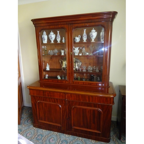 57 - Victorian mahogany two door bookcase, the base fitted with drawers and cupboards. W. 155cm, D. 65cm,... 