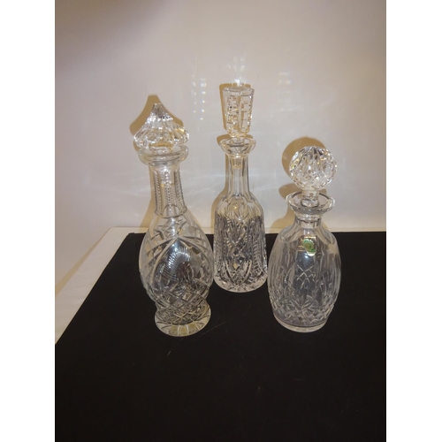 61 - Three Waterford glass decanters and stoppers.