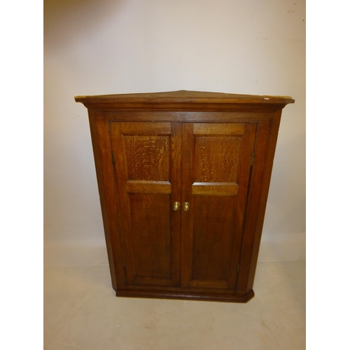 112 - Georgian oak hanging corner cabinet with shelved interior. W. 85cm, H. 110cm, D. 50cm.