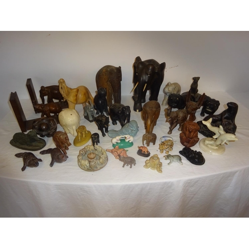 126 - A lot of carved wood elephants and china, marble and metal figures of animals.