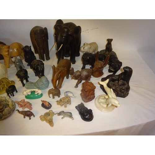 126 - A lot of carved wood elephants and china, marble and metal figures of animals.