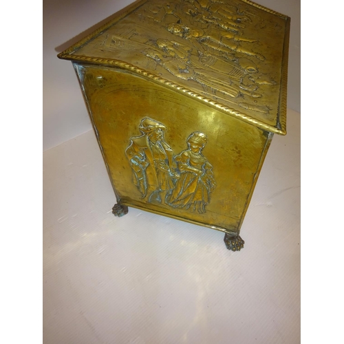 141 - Good old brass coal box with raised figure decoration, complete with liner. W. 57cm.