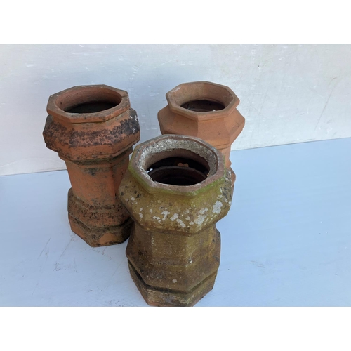 236 - Three old terracotta chimney pots. H. 60cm.