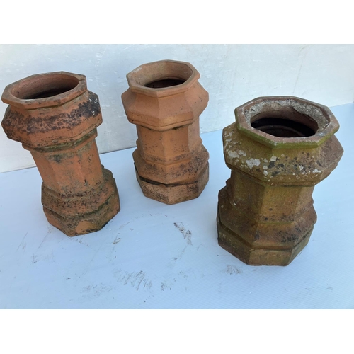 236 - Three old terracotta chimney pots. H. 60cm.