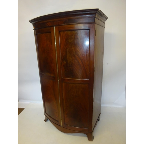 325 - Antique mahogany bow shaped wardrobe having panel doors and raised on splay feet. W. 100cm, H. 173cm... 