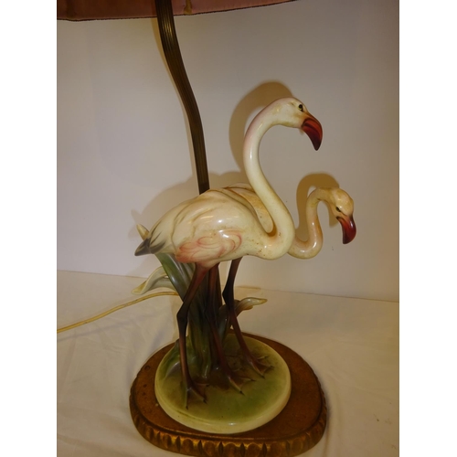 37 - An attractive side lamp in the form of two china flamingo's and old pleated shade. Overall height 68... 