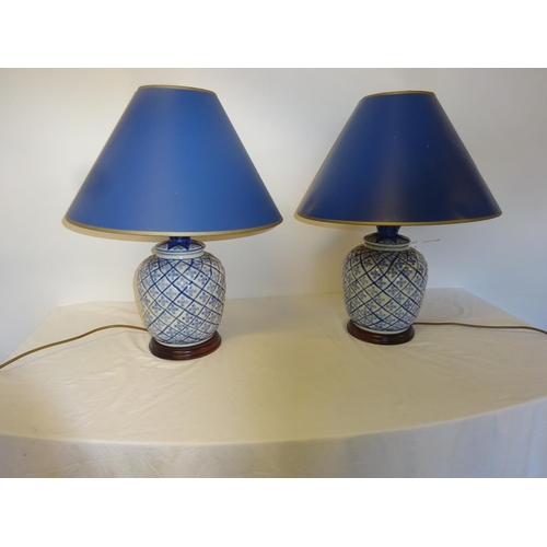 83 - A pair of blue china side lamps and shades. Overall height 55cm.