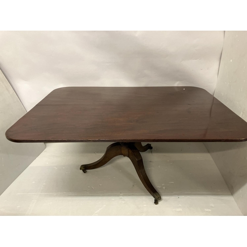 121 - A large Georgian mahogany dining table, the rectangular shaped top with reeded edge and raised on ce... 