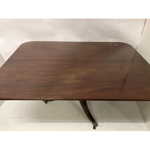 121 - A large Georgian mahogany dining table, the rectangular shaped top with reeded edge and raised on ce... 