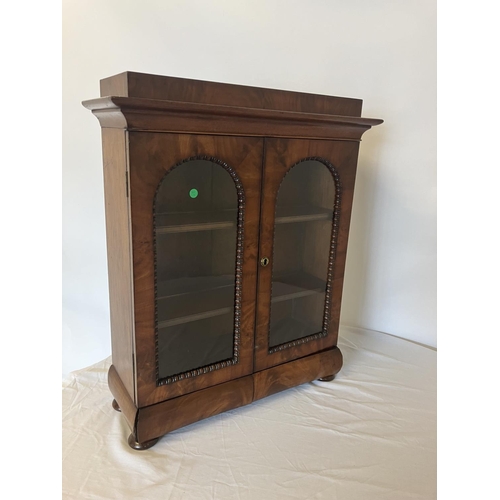 155 - A neat size mid 19th century table top mahogany cabinet having two arched doors with glass panels, t... 