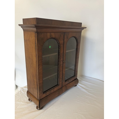 155 - A neat size mid 19th century table top mahogany cabinet having two arched doors with glass panels, t... 