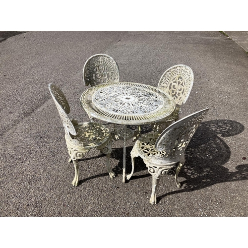 237 - A cast aluminium circular garden table and four chairs.