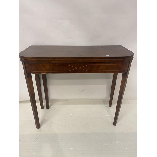 258 - An Irish Georgian inlaid mahogany card table, the D shaped folding top raised on tapered legs. W. 90... 