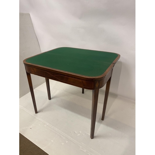 258 - An Irish Georgian inlaid mahogany card table, the D shaped folding top raised on tapered legs. W. 90... 