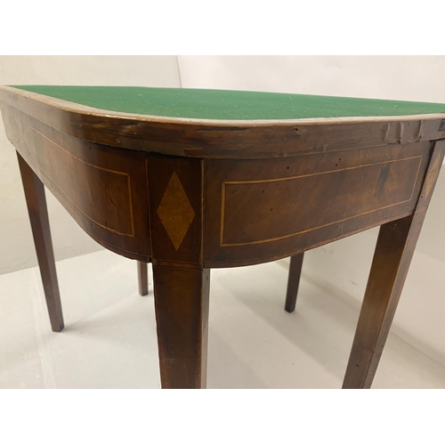 258 - An Irish Georgian inlaid mahogany card table, the D shaped folding top raised on tapered legs. W. 90... 