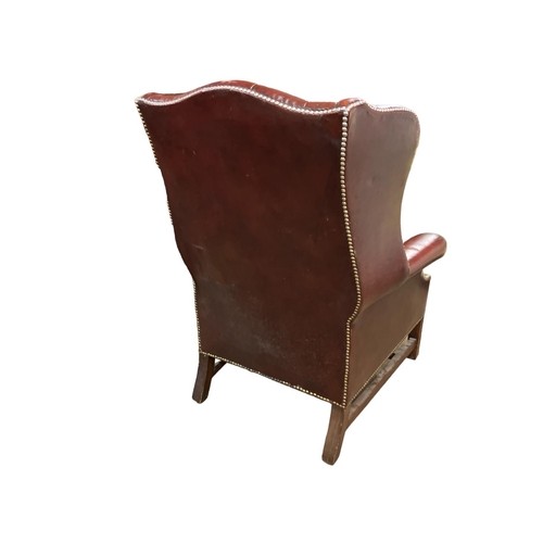 283 - Antique mahogany and leather upholstered wing back library chair.