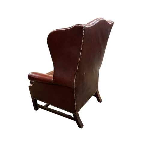 283 - Antique mahogany and leather upholstered wing back library chair.