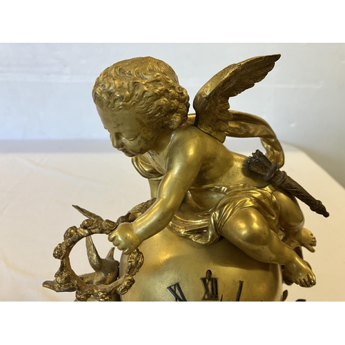 307 - A fine 19th century gilded brass mantle clock, the clock decorated with cherub figures and porcelain... 