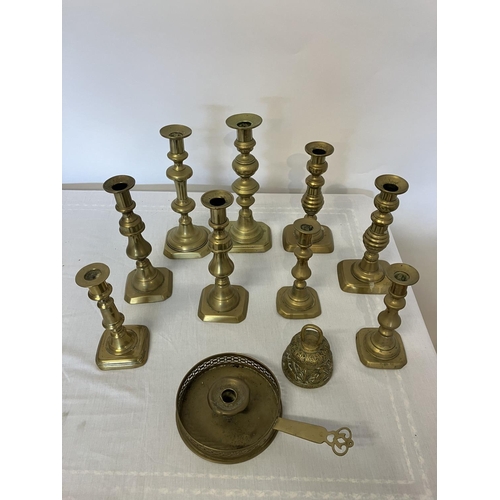 32 - Quantity of antique brass candlesticks, chamber stick and bells.  (11)