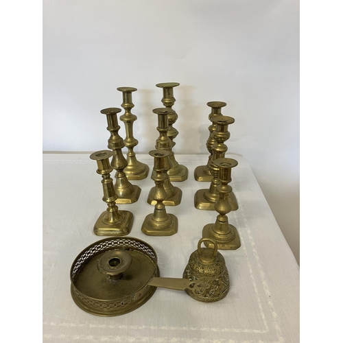 32 - Quantity of antique brass candlesticks, chamber stick and bells.  (11)