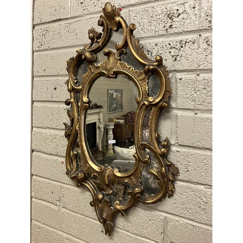 64 - Antique decorative gilt framed wall mirror. L. 80cm, W. 45cm approx.