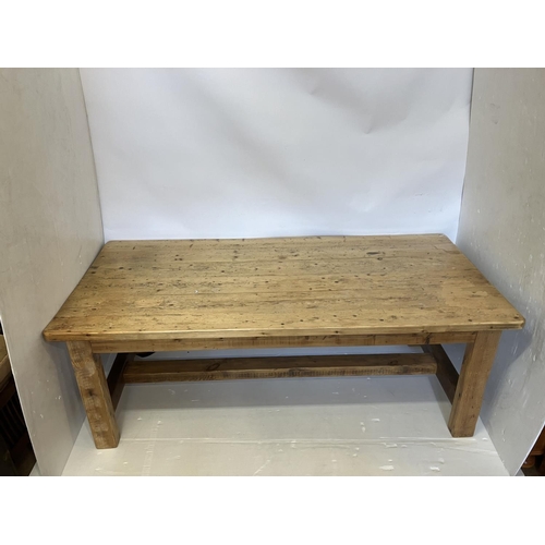 71 - A large pine farmhouse kitchen table raised on square legs with cross stretchers. L. 210cm, W. 100cm... 