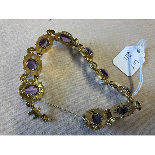 211 - A decorative 9ct gold bracelet with 9 amethyst stones. Clasp needs attention. Length 20cm approx.