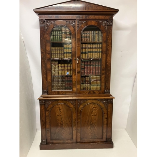 100 - A fine Victorian figured mahogany bookcase, the upper section having shaped cornice over mahogany an... 