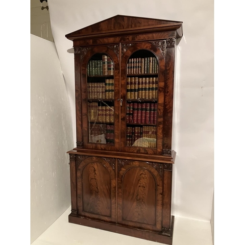 100 - A fine Victorian figured mahogany bookcase, the upper section having shaped cornice over mahogany an... 