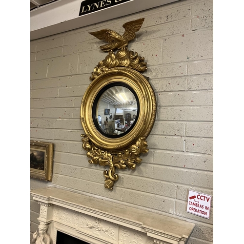 119 - A fine antique gilt framed convex mirror having carved decoration and surmounted with a large eagle,... 