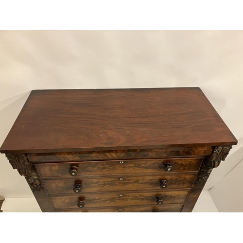 130 - A large Victorian feathered mahogany chest of 6 graduated drawers with carved decoration and raised ... 