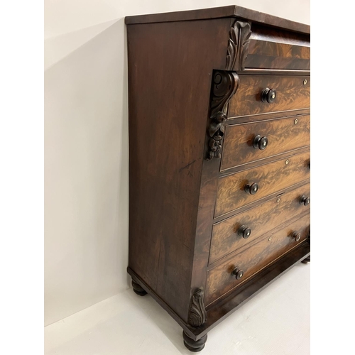 130 - A large Victorian feathered mahogany chest of 6 graduated drawers with carved decoration and raised ... 