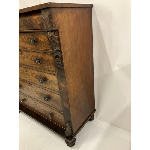 130 - A large Victorian feathered mahogany chest of 6 graduated drawers with carved decoration and raised ... 