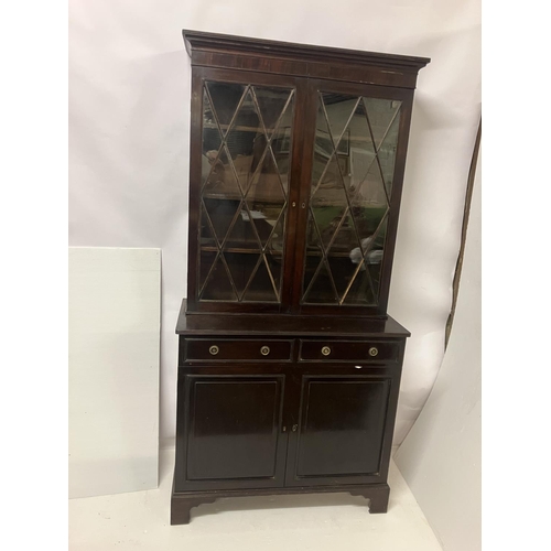 147 - A 19th century mahogany bookcase, the upper section having two glazed diamond doors, the base fitted... 