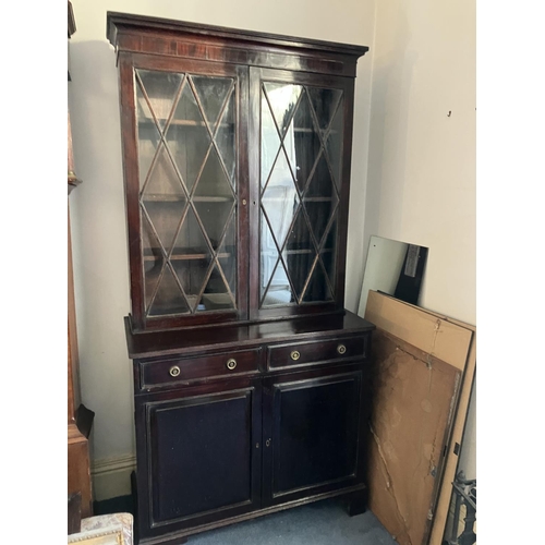 147 - A 19th century mahogany bookcase, the upper section having two glazed diamond doors, the base fitted... 