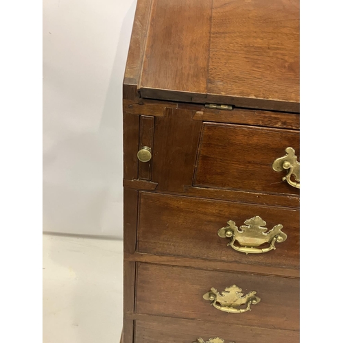 297 - Georgian mahogany slope front bureau having fitted interior, four graduated drawers with brass handl... 