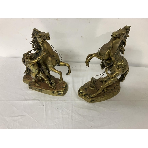 381 - Pair of antique brass Marley horses and horsemen. H. 29cm.