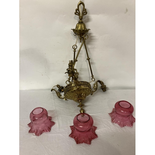 383 - Decorative brass chandelier with red glass shades. Drop 70cm approx.