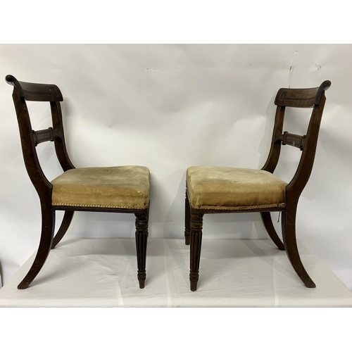 49 - In the manner of Gillows, a pair of Regency mahogany side chairs having curved top rail decorative b... 